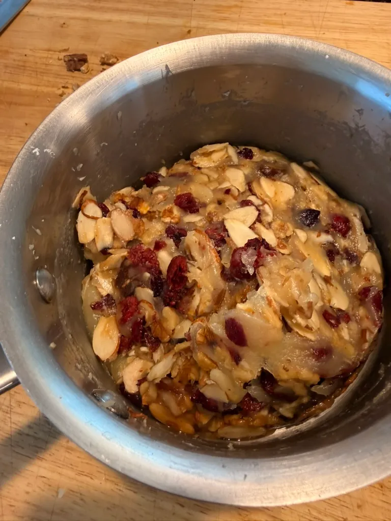 The almonds, walnuts, cranberries, and dates folded into the caramel base in the saucepan.