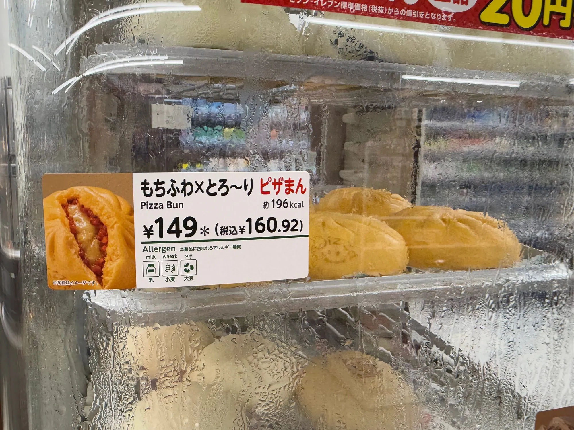 Pizza buns in a Japanese convenience store hot case with a label reading Pizza Bun, 149 yen.